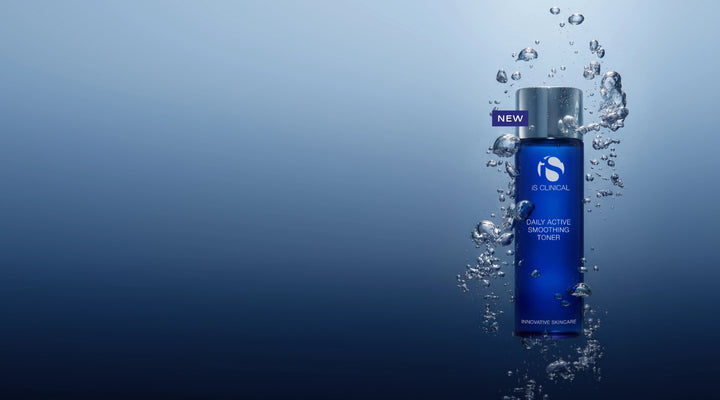 Blue bottle of iS Clinical Daily Active Smoothing Toner surrounded by rising water bubbles on a gradient blue background