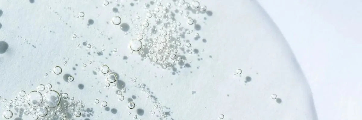 Close-up of clear liquid with suspended bubbles on a white background