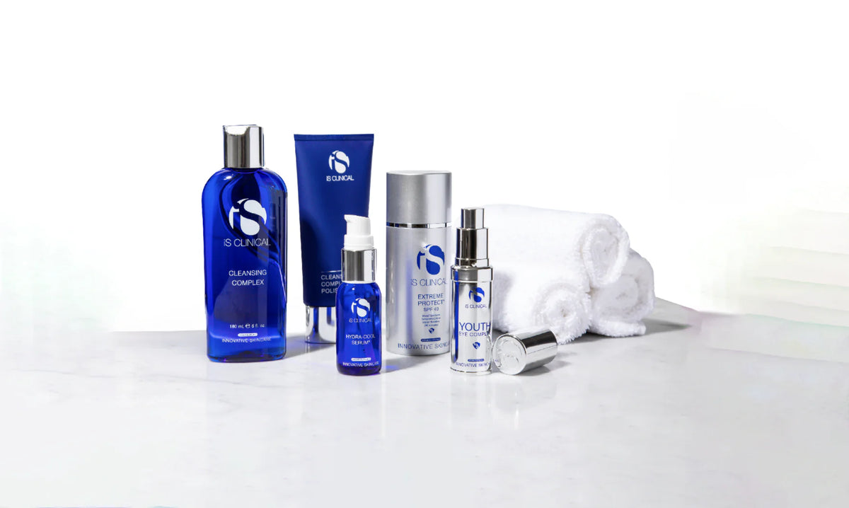 iS Clinical Cleansing Complex, Hydra-Cool Serum, Extreme Protect SPF 40 and rolled white towels