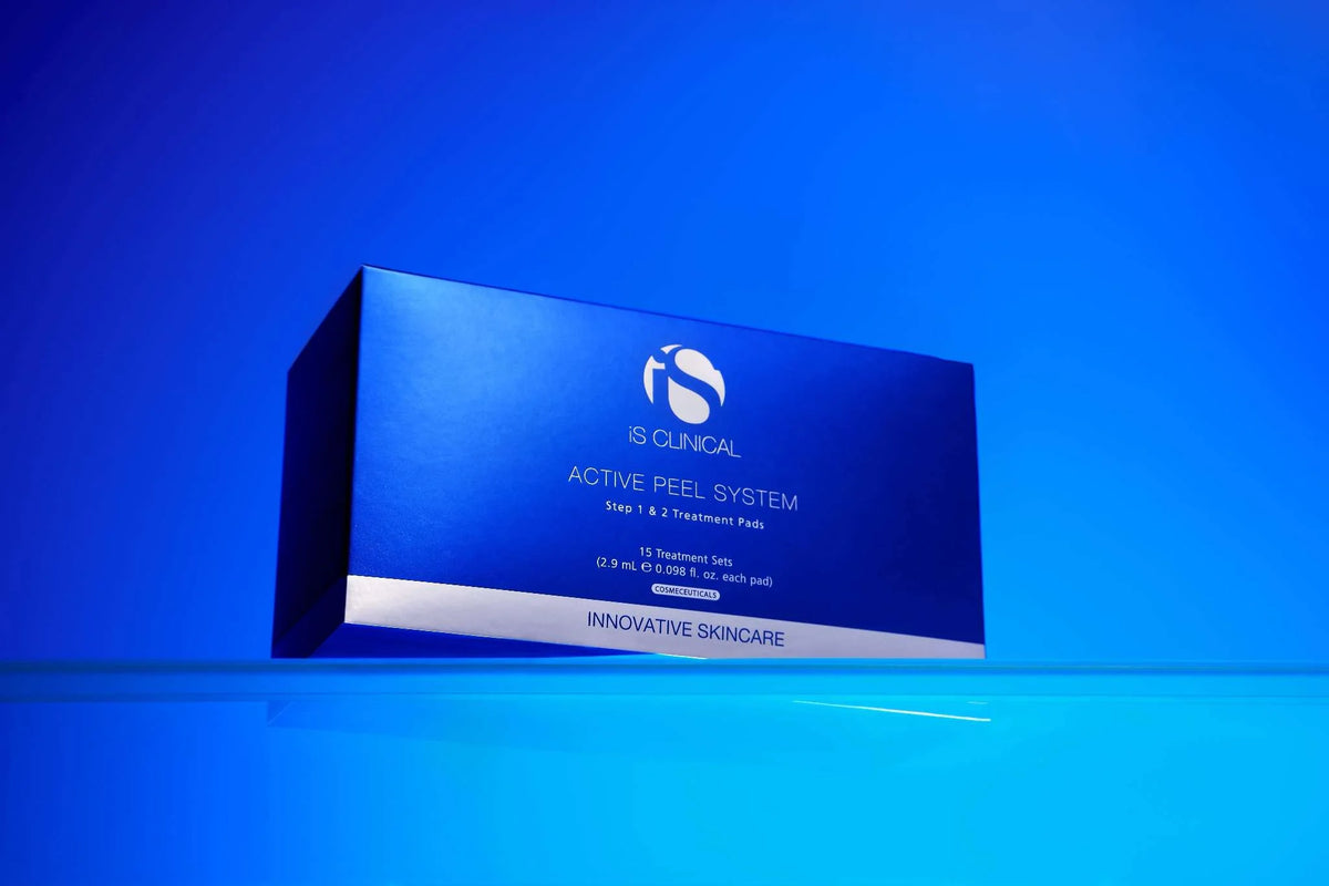Blue box of iS Clinical Active Peel System treatment pads on reflective blue surface