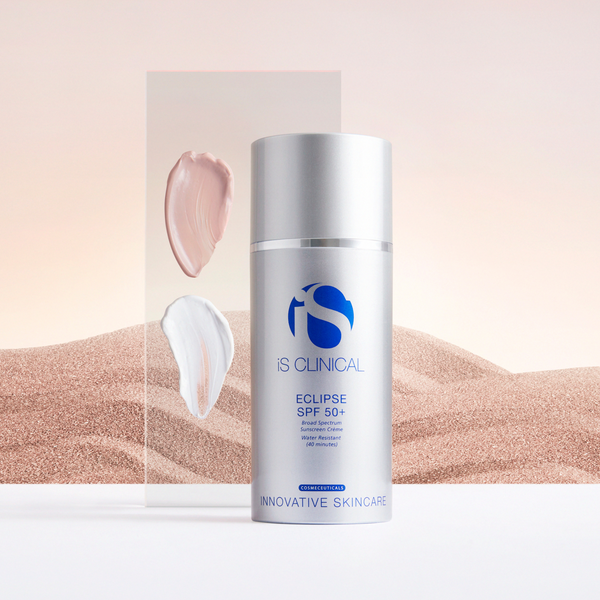 Silver pump bottle of iS Clinical Eclipse SPF 50+ with blue logo and text, cream swatches on transparent panel