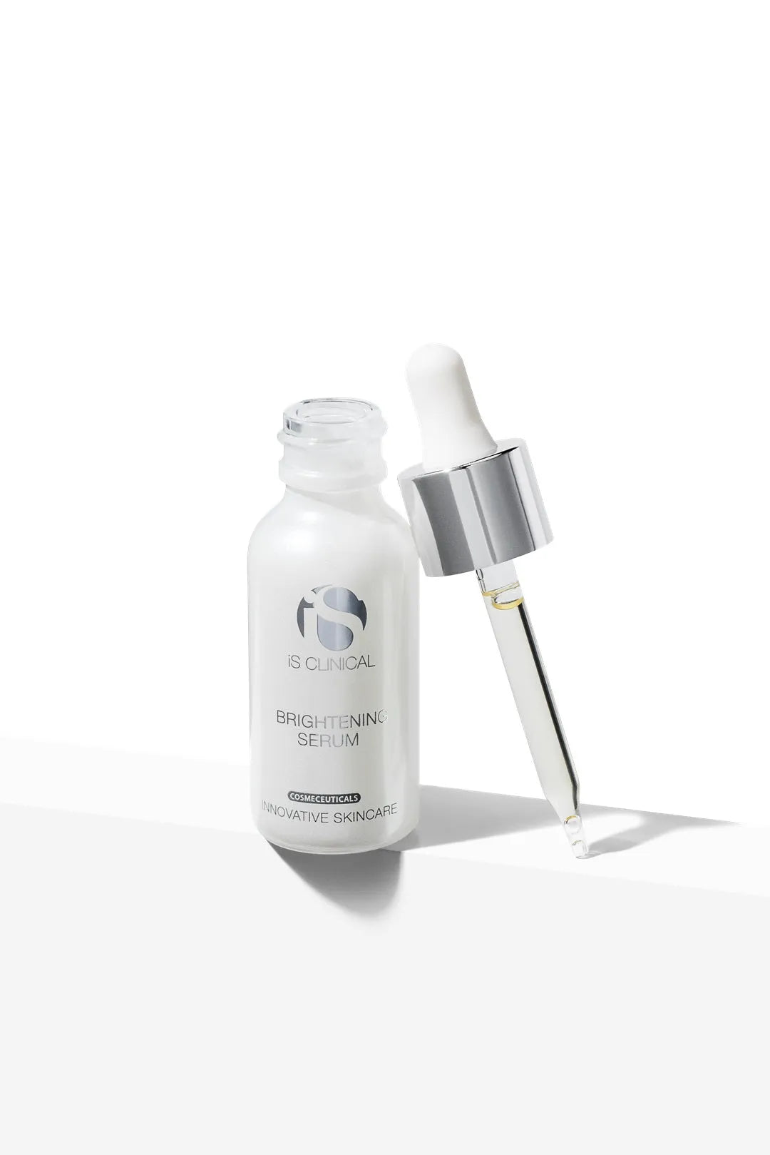 Open frosted glass bottle of iS Clinical Brightening Serum with silver and white dropper beside it