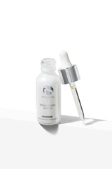 Open frosted glass bottle of iS Clinical Brightening Serum with silver and white dropper beside it