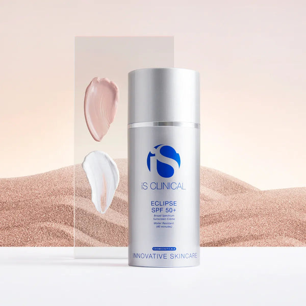 Silver pump bottle of iS Clinical Eclipse SPF 50+ sunscreen with beige and white cream swatches on clear panel
