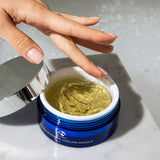 Hand scooping clear gel from an open blue jar of iS Clinical Hydra-Intensive Cooling Masque