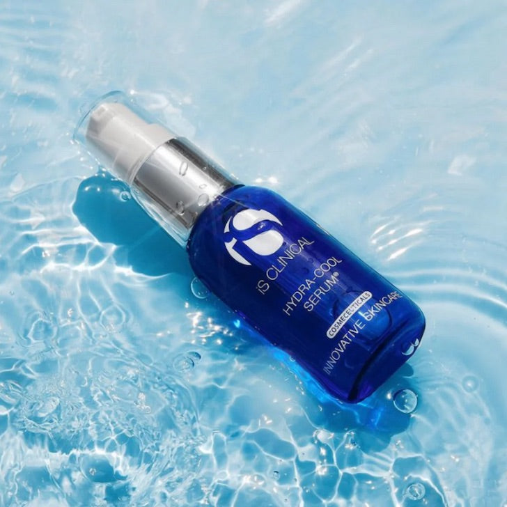 Blue iS Clinical Hydra-Cool Serum bottle with white pump on water surface with light reflections