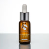 Amber glass dropper bottle of iS Clinical Pro-Heal Serum Advance+ with silver cap on reflective surface