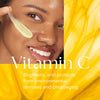 Close-up of smiling woman applying pale yellow emulsion to cheek with text about Vitamin C benefits
