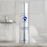 Silver cylindrical bottle of iS Clinical NeckPerfect Complex on a bathroom counter